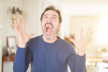 Yakışıklı orta yaş adam evde deli ve deli bağırarak ve agresif ifade ve kollar kaldırdı ile bağırıyor. Hayal kırıklığı kavramı.