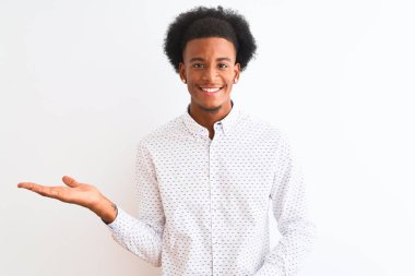 Genç afro-amerikan adam izole beyaz arka plan üzerinde duran zarif gömlek giyen neşeli sunan gülümseyerek ve kameraya bakarak avuç içi ile işaret.