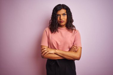 Izole pembe arka plan şüpheci ve sinir üzerinde Genç güzel transseksüel transseksüel zarif kadın, çapraz kolları ile yüzünde ifade onaylamayan. Negatif kişi.