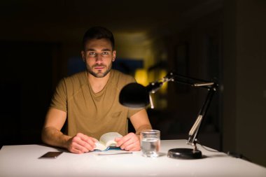 Genç yakışıklı öğrenci adam evde gece okuyan akıllı yüz ciddi düşünme kendine güvenen bir ifade ile