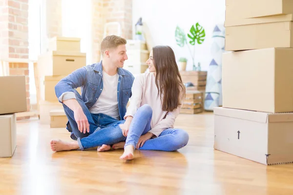 Jovem casal bonito relaxante sentado no chão em torno do cartão — Fotografia de Stock