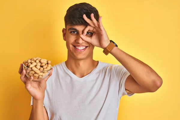 Young Indian Man Holding Bowl Peanuts Isolated Yellow Background Happy — Stock Photo, Image