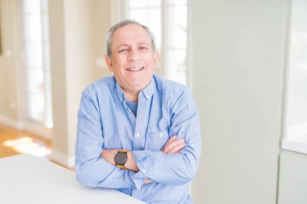 Hombre mayor guapo sonriendo confiado con los brazos cruzados — Foto de Stock