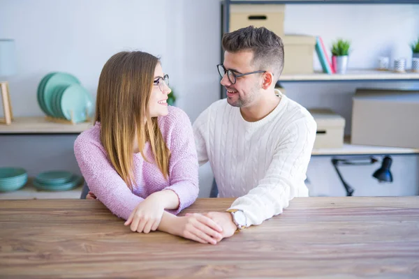 Junges Schönes Paar Das Hause Auf Dem Tisch Sitzt Und — Stockfoto