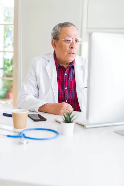 Старший лікар у клініці сконцентрований на роботі з комп'ютером — стокове фото