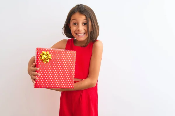孤立した白い背景の上に立つ誕生日プレゼントを持つ美しい少女は 歯を見せる自信のある笑顔で立ち上がり 笑顔を浮かべています — ストック写真