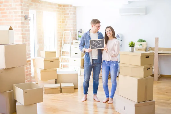 Schönes junges Paar, das sich verliebt umarmt und die Tafel hält — Stockfoto