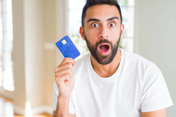 驚き顔 恐怖表現と興奮とショックで怖いクレジット カードを保持しているヒスパニック美男子 — ストック写真