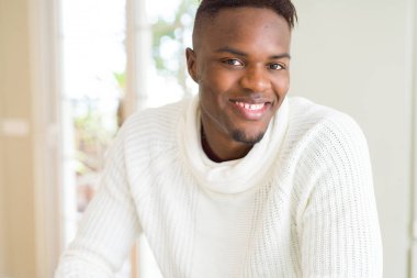 Gülümseyen yüzünde kocaman bir gülümseme ile neşeli Afrika yakışıklı genç