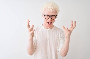 Genç albino sarışın adam t-shirt ve gözlük giyen izole beyaz arka plan üzerinde deli kutluyor ve kollarını kaldırdı ve açık gözleri heyecan çığlık ile başarı için hayran. Kazanan kavramı