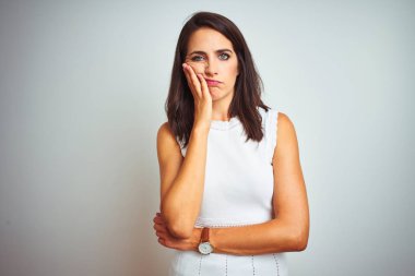 Beyaz izole arka plan üzerinde duran elbise giyen genç güzel kadın yorgun görünümlü ve çapraz kolları ile depresyon sorunları ile sıkılmış düşünme.
