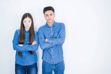 Beyaz izole arka plan şüpheci ve sinir üzerinde Güzel genç asyalı çift, çapraz kolları ile yüzünde onaylamayan ifade. Negatif kişi.
