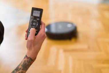 Adam elleri kontrol otomatik elektrikli süpürge kullanarak yakın 