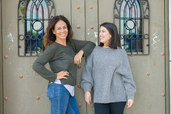 Beautiful family of mother and daughter smiling cheerful, two ha — Stock Photo, Image