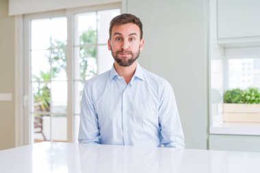 Yakışıklı iş adamı komik suratla yanaklarını şişiriyor. Ağız hava ile şişirilmiş, deli ifade.