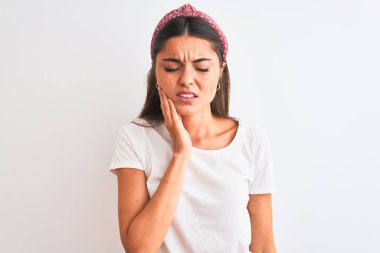 Genç güzel kadın gündelik t-shirt giyen ve izole beyaz arka plan üzerinde diş ağrısı veya diş hastalığı nedeniyle ağrılı ifade ile el ile ağız dokunmadan. Diş hekimi konsepti.