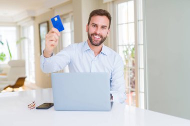 Yakışıklı iş adamı alışveriş online bilgisayar dizüstü kullanarak ve 