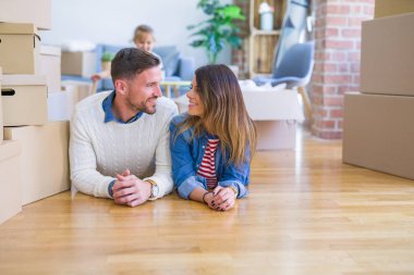 Karton kutular etrafında yeni evde yatan çocuk ile güzel famiily