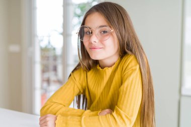 Güzel genç kız çocuk yüzünde mutlu ve serin bir gülümseme ile gözlük giyiyor. Şanslı kişi.