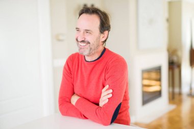 Evde kameraya bakarak gülümseyen yakışıklı orta yaş erkek