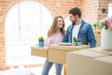 Yeni bir ev taşımak karton kutular tutarak birlikte çok mutlu genç güzel çift