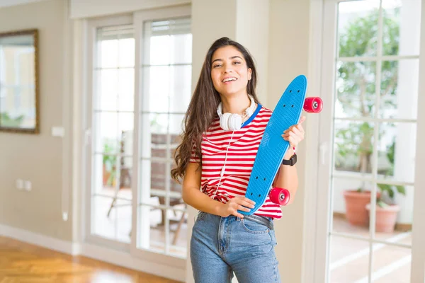 Schöne Skaterin freundlich lächelnd mit Skateboard stehend — Stockfoto