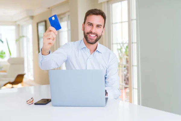 Hombre de negocios guapo compras en línea utilizando ordenador portátil y —  Fotos de Stock