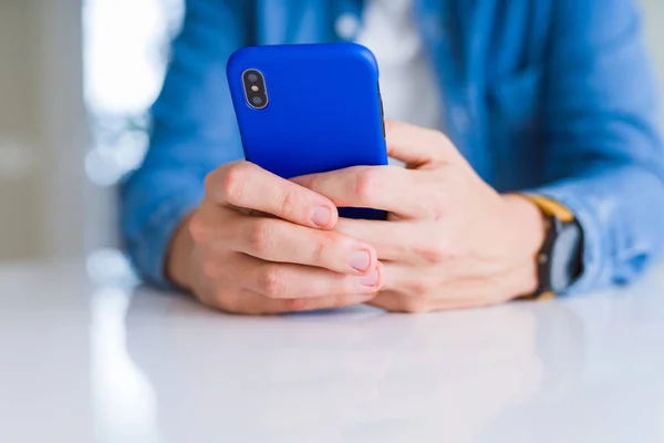 Close up of man hands using smartphone and smiling — Stock Photo, Image