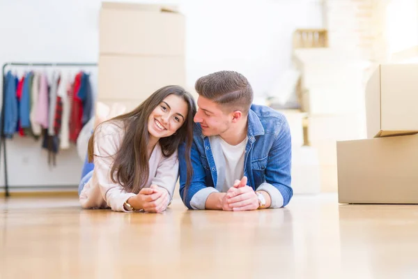 Jovem casal bonito relaxante deitado no chão em torno de cardbo — Fotografia de Stock