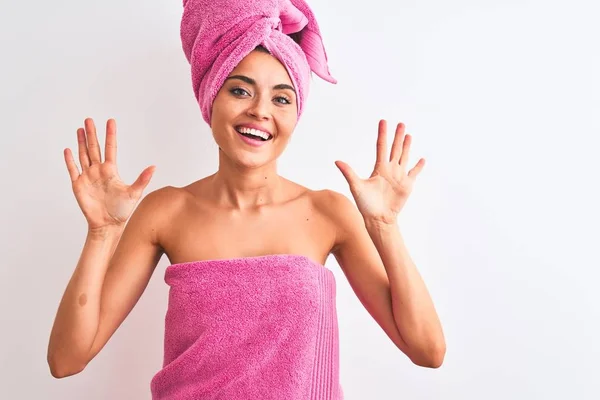 年轻的美女穿着淋浴毛巾后洗澡在孤立的白色背景显示和指着手指数字十 同时微笑自信和快乐 — 图库照片