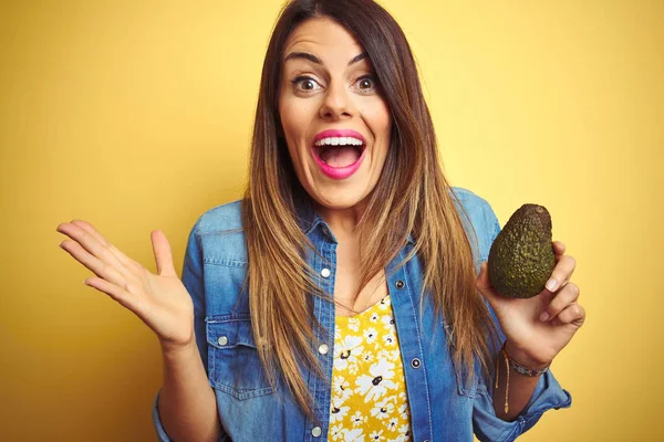 Joven Hermosa Mujer Comiendo Aguacate Saludable Sobre Fondo Amarillo Muy —  Fotos de Stock