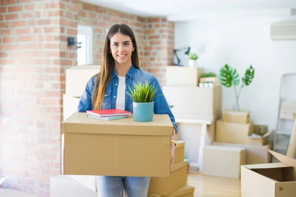 Mooie jonge vrouw Holding kartonnen doos in nieuw appartement, SM — Stockfoto