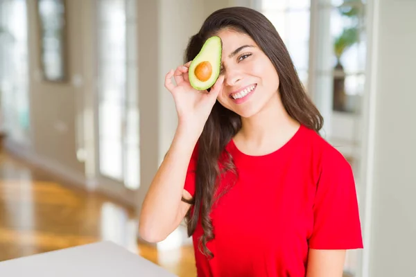 Güzel genç kadın tutan sağlıklı avokado ve gülümseyen — Stok fotoğraf