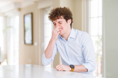 Kıvırcık okuyan genç iş adamı, kokuşmuş ve bir koku kokuyor, dayanılmaz kokuyor, burnunda parmaklarıyla nefes tutuyor. Kötü kokular kavramı.