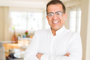 Evde kameraya gülümseyen gözlük takan orta yaş erkek