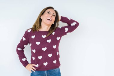 İzole arka plan üzerinde kalp kazak giyen güzel orta yaş kadın el kadar jest ile emin dokunmadan saç gülümseyerek, çekici poz