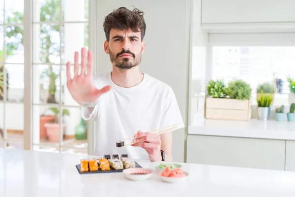 Młody Człowiek Jedzenia Asian Sushi Dostawą Domu Otwartą Ręką Robi — Zdjęcie stockowe