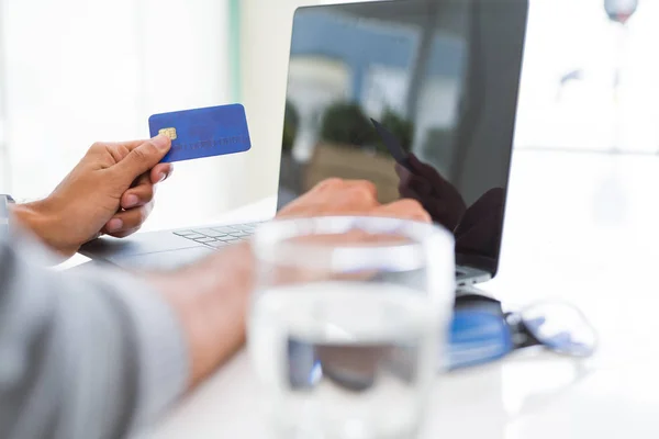 Mann benutzt Kreditkarte als Zahlungsmittel beim Online-Einkauf — Stockfoto