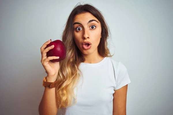 Giovane Bella Donna Mangiare Mela Rossa Sfondo Grigio Isolato Spaventato — Foto Stock