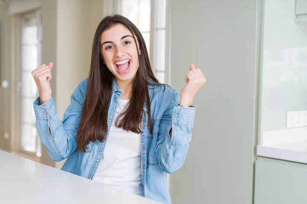 Bella Giovane Donna Seduta Sul Tavolo Bianco Casa Festeggiare Sorpreso — Foto Stock