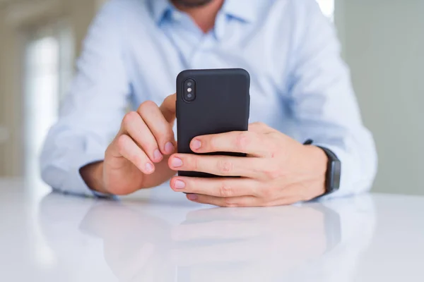 Fechar as mãos do homem usando smartphone e sorrindo — Fotografia de Stock