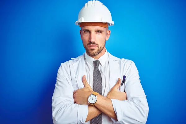 Jonge Knappe Ingenieur Man Dragen Veiligheidshelm Blauwe Geïsoleerde Achtergrond Scepticus — Stockfoto