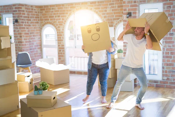 Casal louco usando caixas de papelão com emoji engraçado rostos sobre — Fotografia de Stock