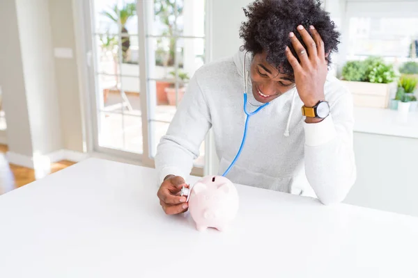 Hombre Afroamericano Sosteniendo Estetoscopio Comprobando Salud Financiera Alcancía Estresado Con — Foto de Stock