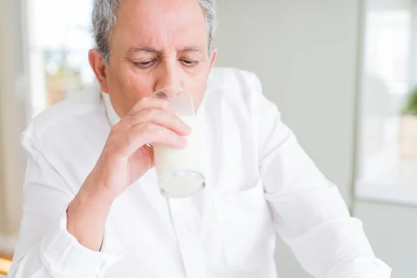 Bell'uomo anziano che beve un bicchiere di latte fresco al mattino — Foto Stock