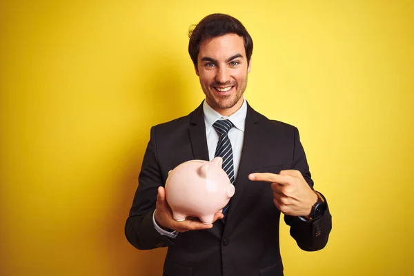Jonge Knappe Zakenman Holding Piggy Bank Geïsoleerde Gele Achtergrond Zeer — Stockfoto