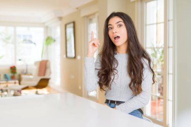 Genç güzel kadın evde parmak ile başarılı fikir işaret. Çıktıktan ve mutlu. Bir numara.
