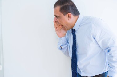 Deli ile bağırarak orta yaş adam ağzının üstüne beyaz duvar arka plan üzerinde eller.