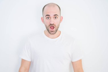 Beyaz izole arka plan üzerinde genç kel adam korkmuş ve sürpriz ifade, korku ve heyecanlı yüz ile şok.