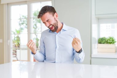 Gülümseyen ve başarı için çığlık yakışıklı iş adamı çok mutlu ve heyecanlı kaldırdı, silah ile kazanan jest yapıyor. Kutlama kavramı.